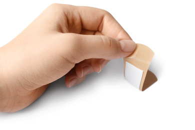 Photo of Woman putting sticking plaster on white background. First aid item
