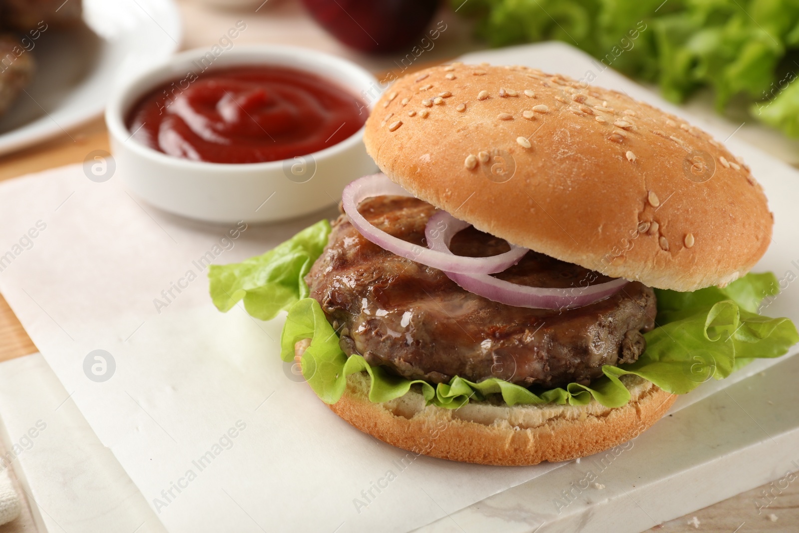 Photo of Tasty hamburger with patty and vegetables served on table, closeup. Space for text