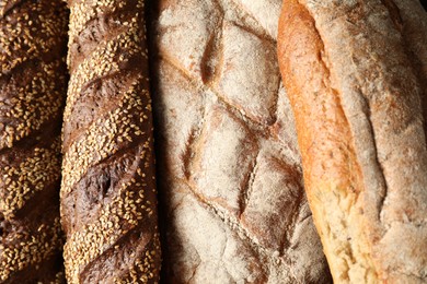 Different types of fresh bread as background, top view