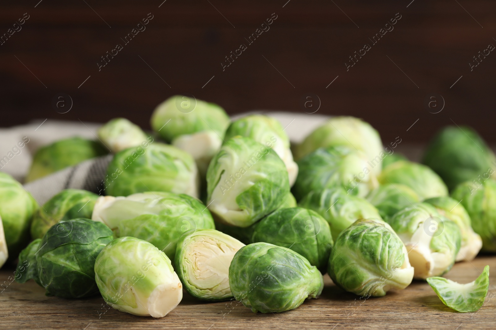 Photo of Fresh Brussels sprouts on wooden table, closeup