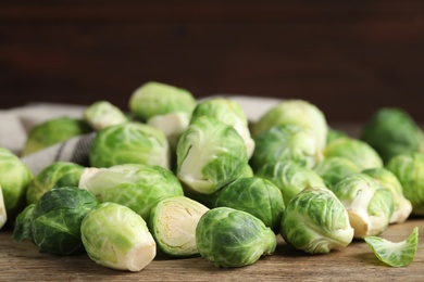 Photo of Fresh Brussels sprouts on wooden table, closeup