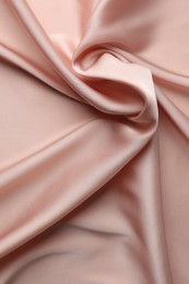 Photo of Crumpled pink silk fabric as background, top view
