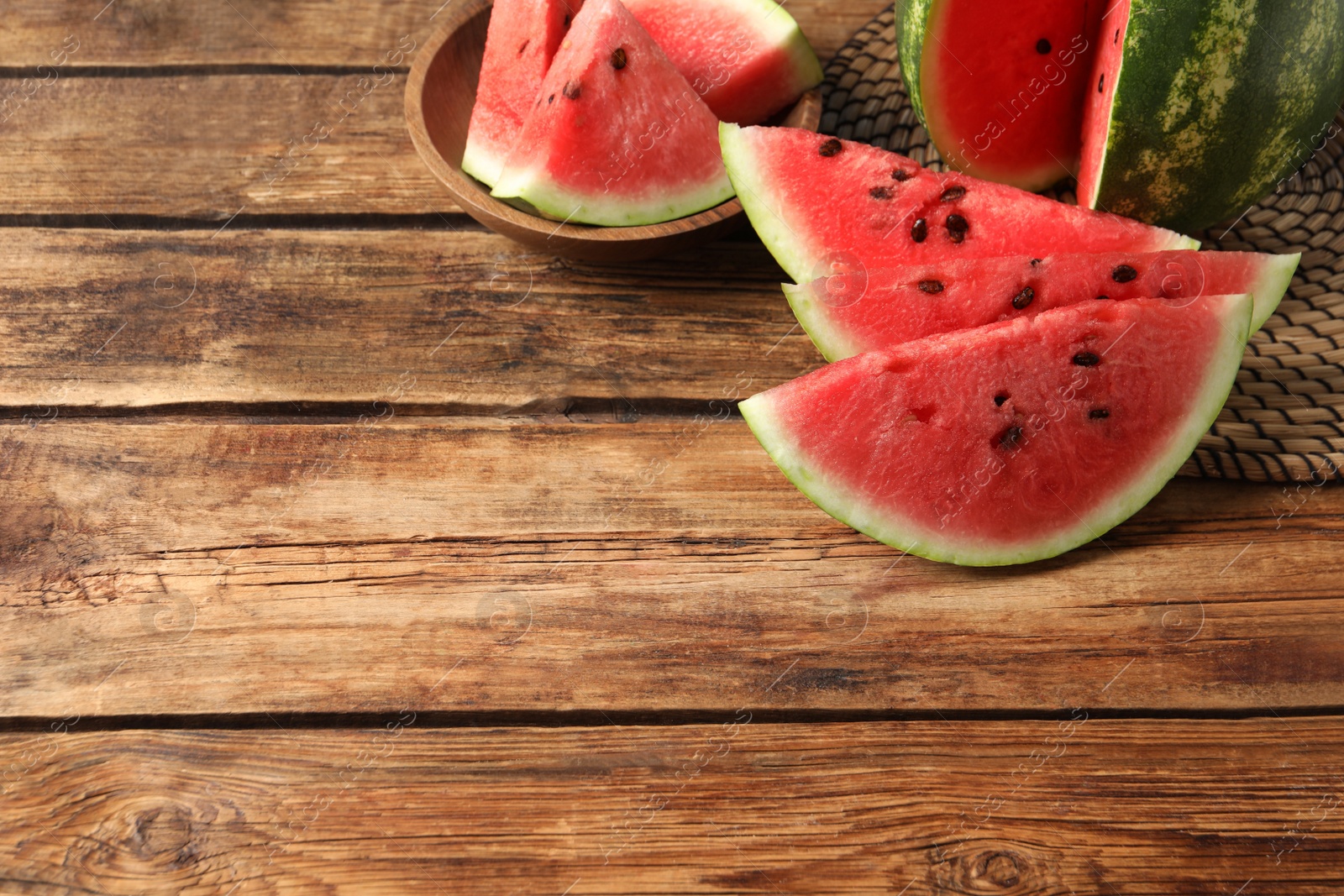 Photo of Delicious fresh watermelon slices on wooden table. Space for text