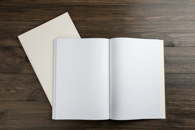 Photo of Blank paper brochures on wooden table, flat lay. Mockup for design