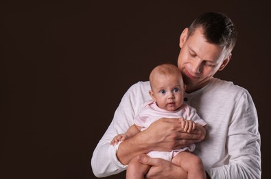 Happy father with his little baby on dark background
