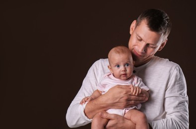 Photo of Happy father with his little baby on dark background