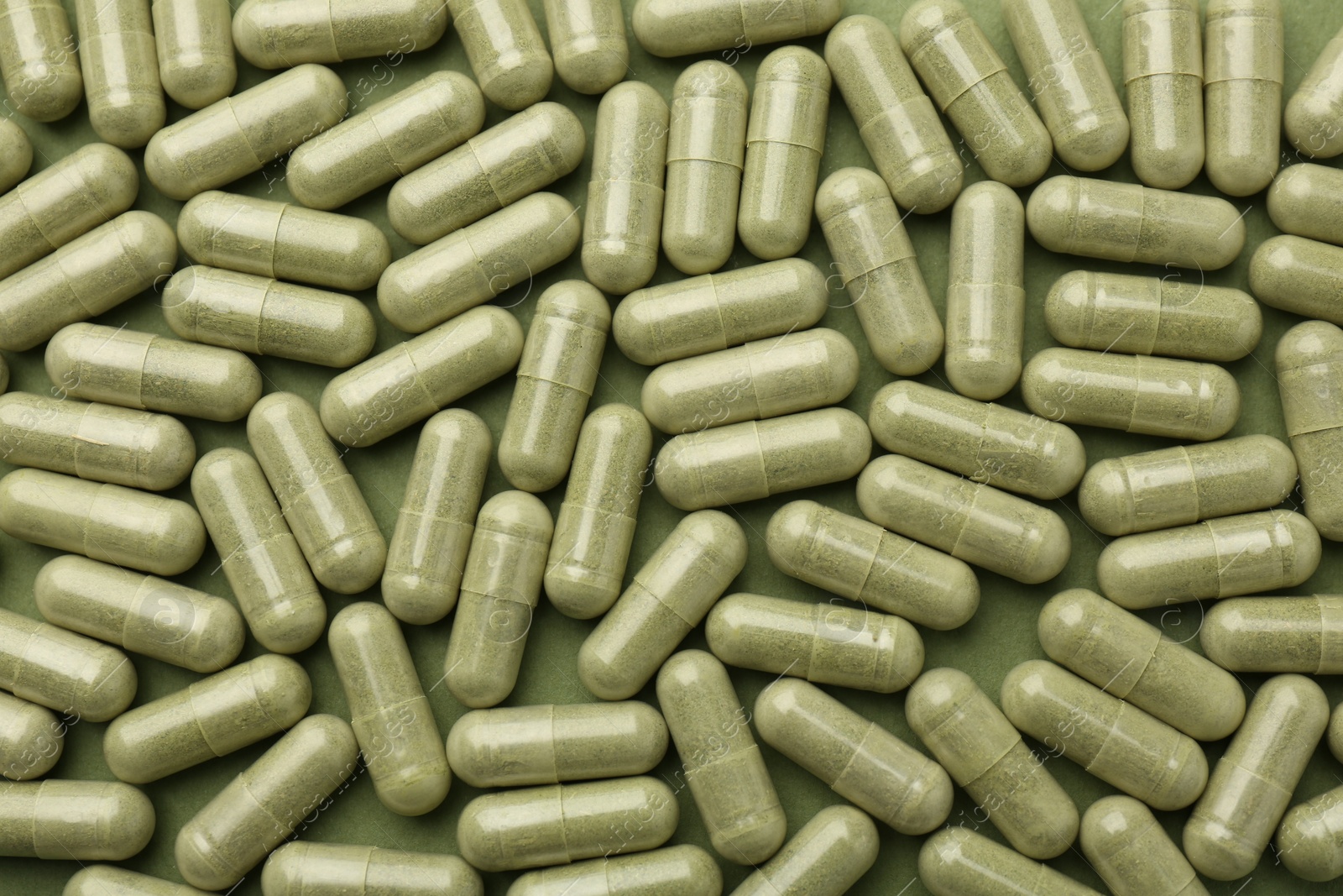 Photo of Vitamin capsules on olive background, flat lay