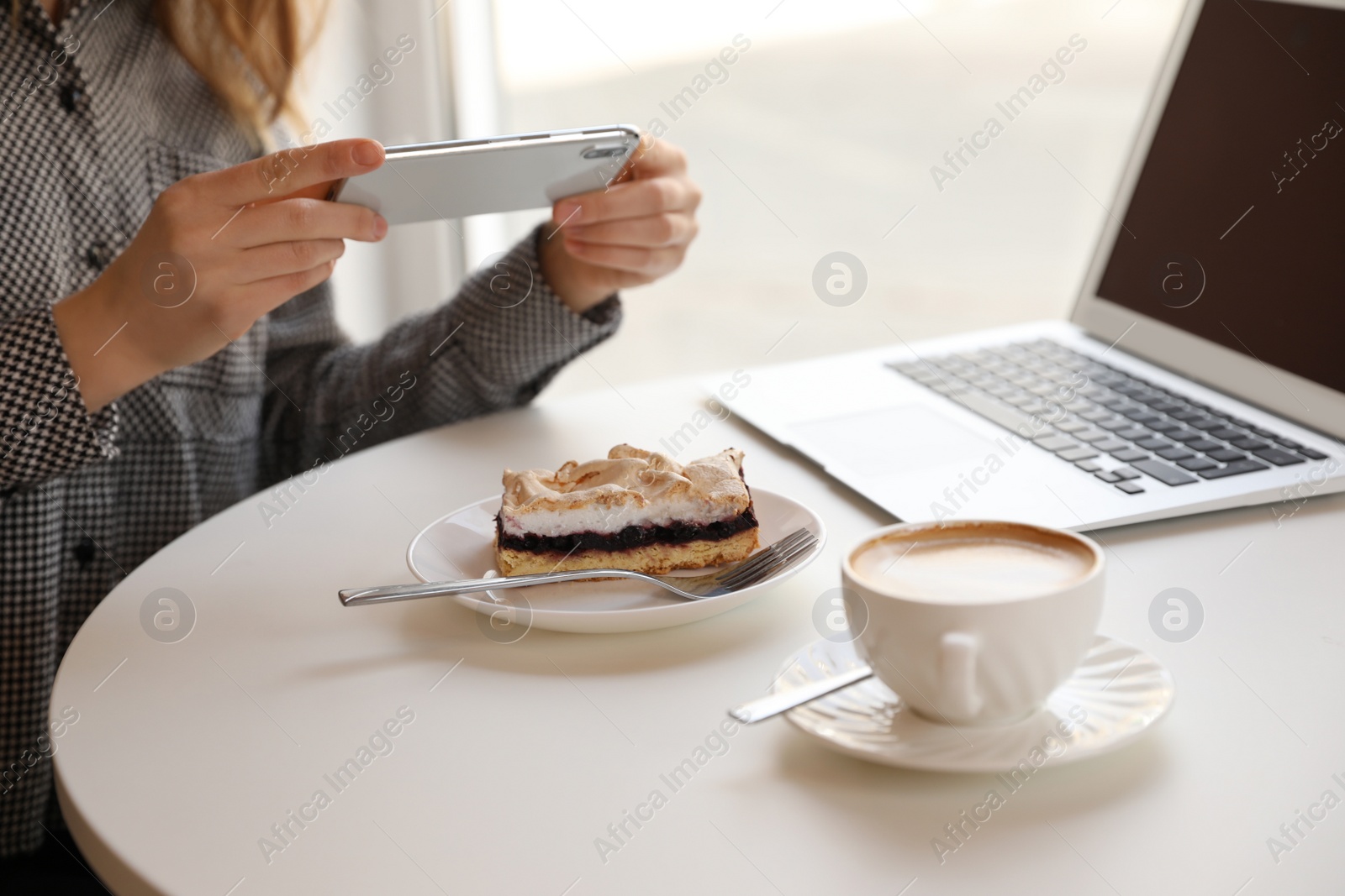 Photo of Young blogger taking photo of dessert in cafe, closeup