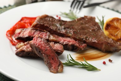 Photo of Delicious grilled beef steak with spices on plate, closeup