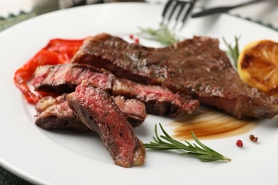 Delicious grilled beef steak with spices on plate, closeup