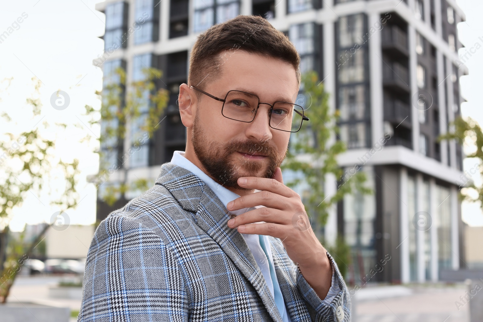 Photo of Portrait of handsome bearded man in glasses outdoors