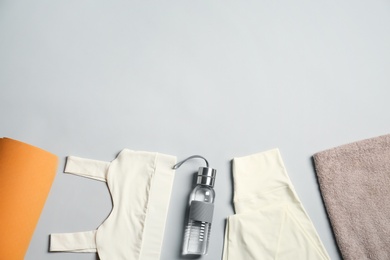 Flat lay composition with yoga equipment on grey background. Space for text