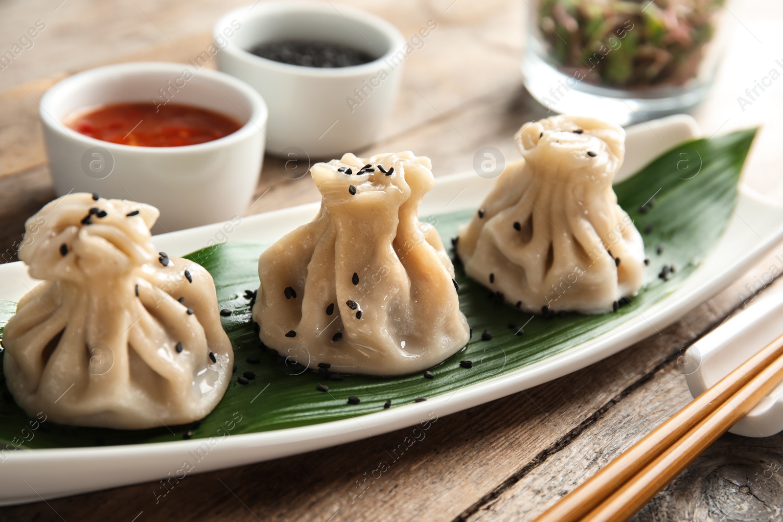 Photo of Plate with tasty baozi dumplings on table, closeup