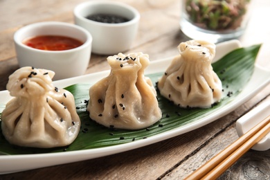 Plate with tasty baozi dumplings on table, closeup