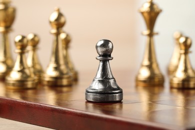 Photo of Chessboard with game pieces on beige background, closeup