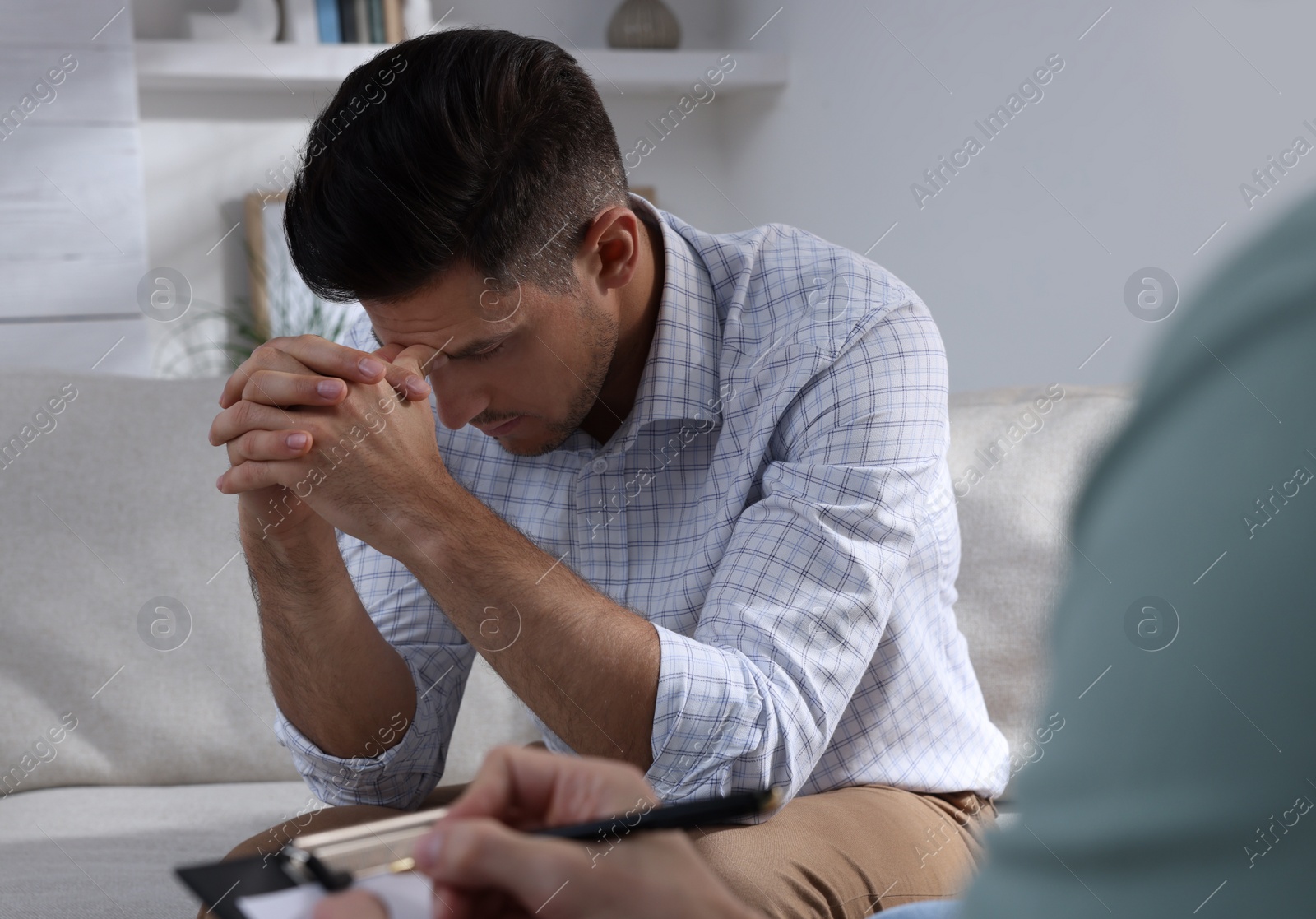 Photo of Unhappy man having session with his therapist indoors