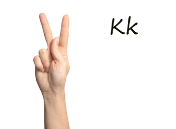 Woman showing letter K on white background, closeup. Sign language