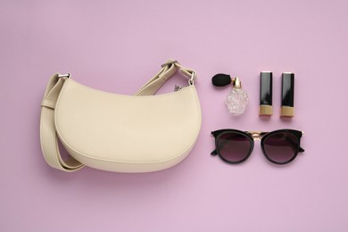 Flat lay composition with stylish baguette handbag on lilac background