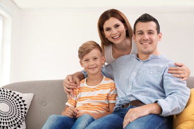 Happy family with cute child on sofa at home