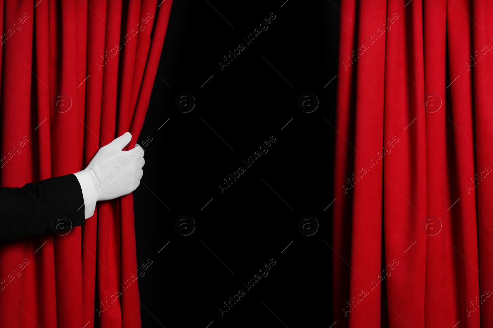 Photo of Person opening red front curtains on black background, closeup. Space for text