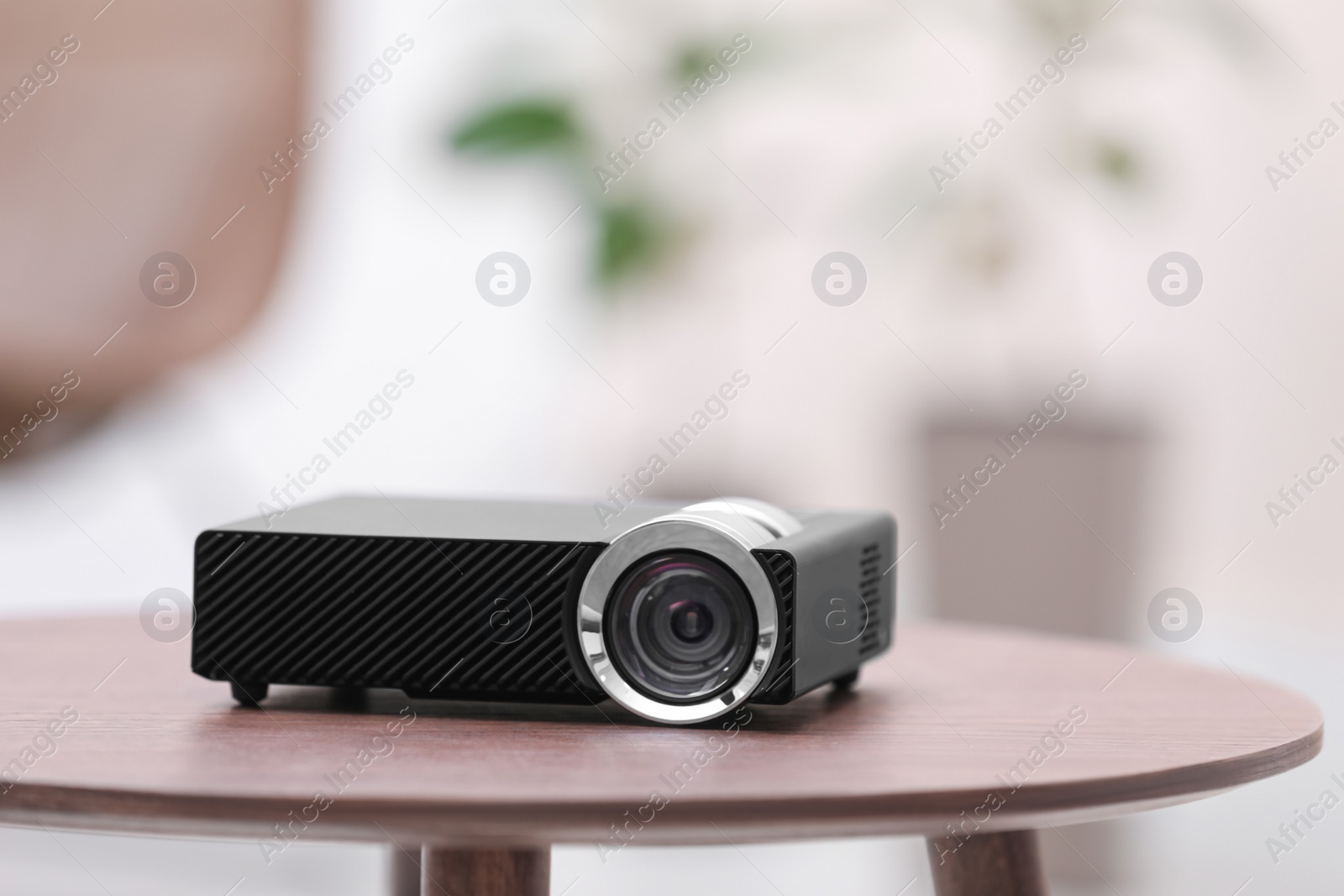 Photo of Modern video projector on wooden table indoors