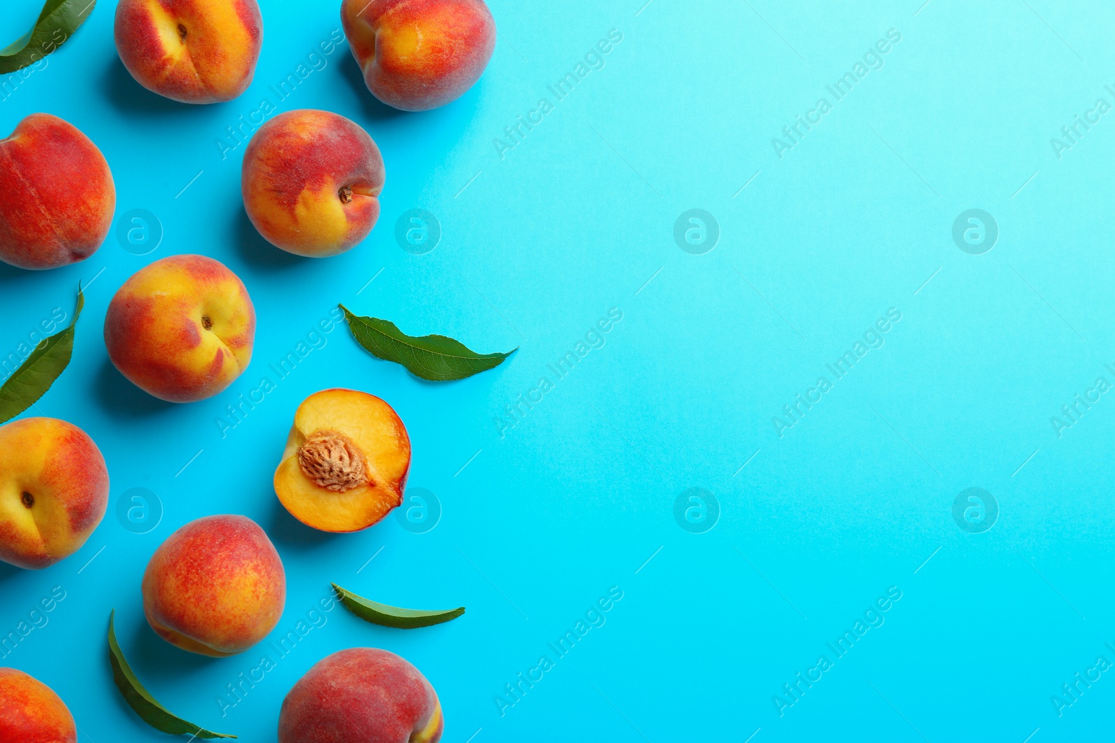 Photo of Flat lay composition with fresh peaches on blue background. Space for text