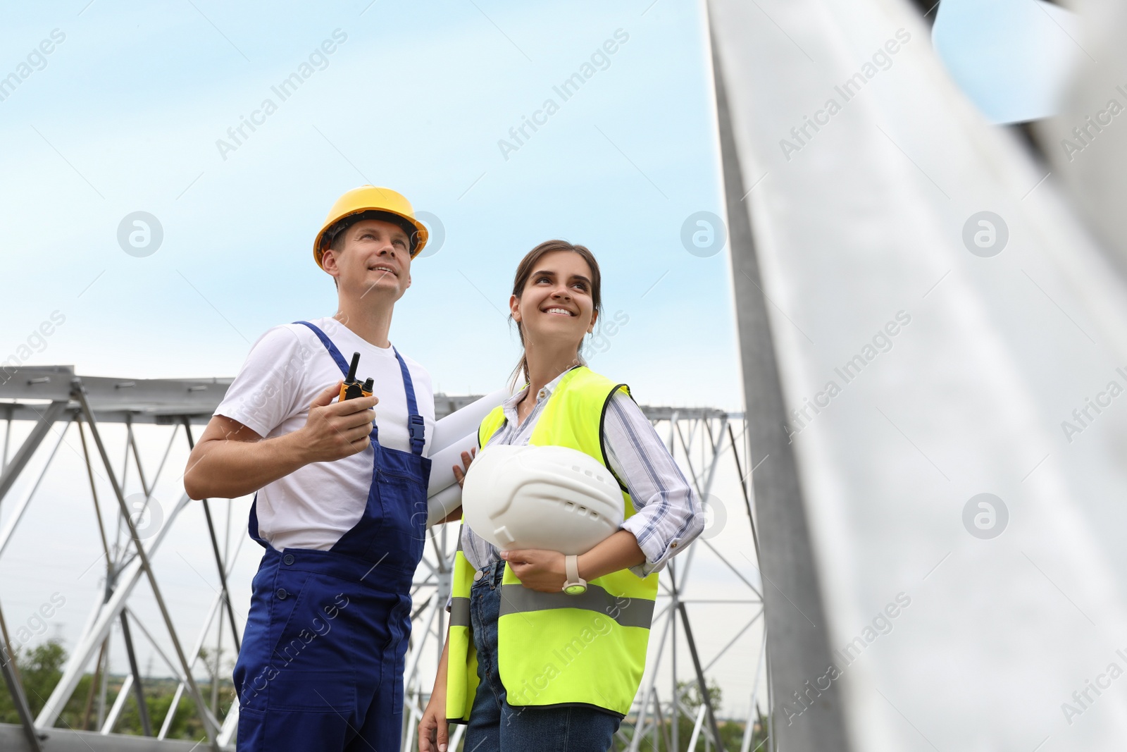 Photo of Professional engineers working on installation of electrical substation outdoors