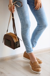 Photo of Young woman wearing elegant shoes indoors, closeup