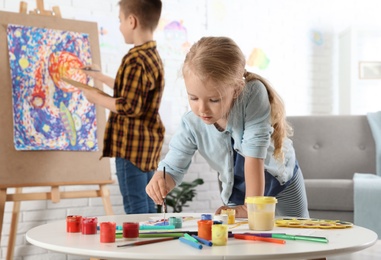 Photo of Cute little children painting together at home
