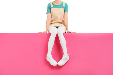 Woman wearing white tights and stylish shoes sitting on color background, closeup