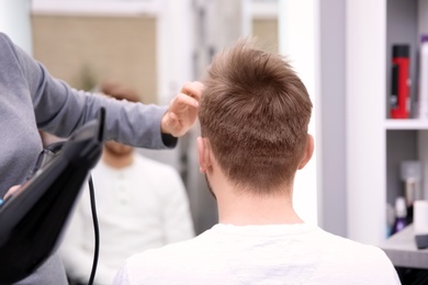 Photo of Professional female hairdresser working with client in salon