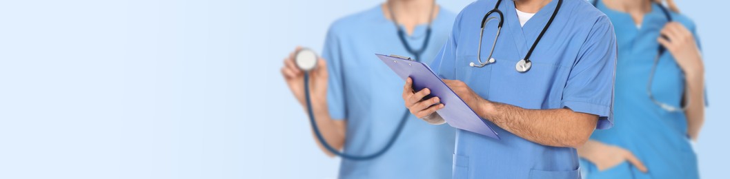 Image of Doctors and nurse on light blue background, closeup. Banner design with space for text