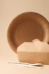 Eco friendly food packaging. Paper container and tableware on beige background