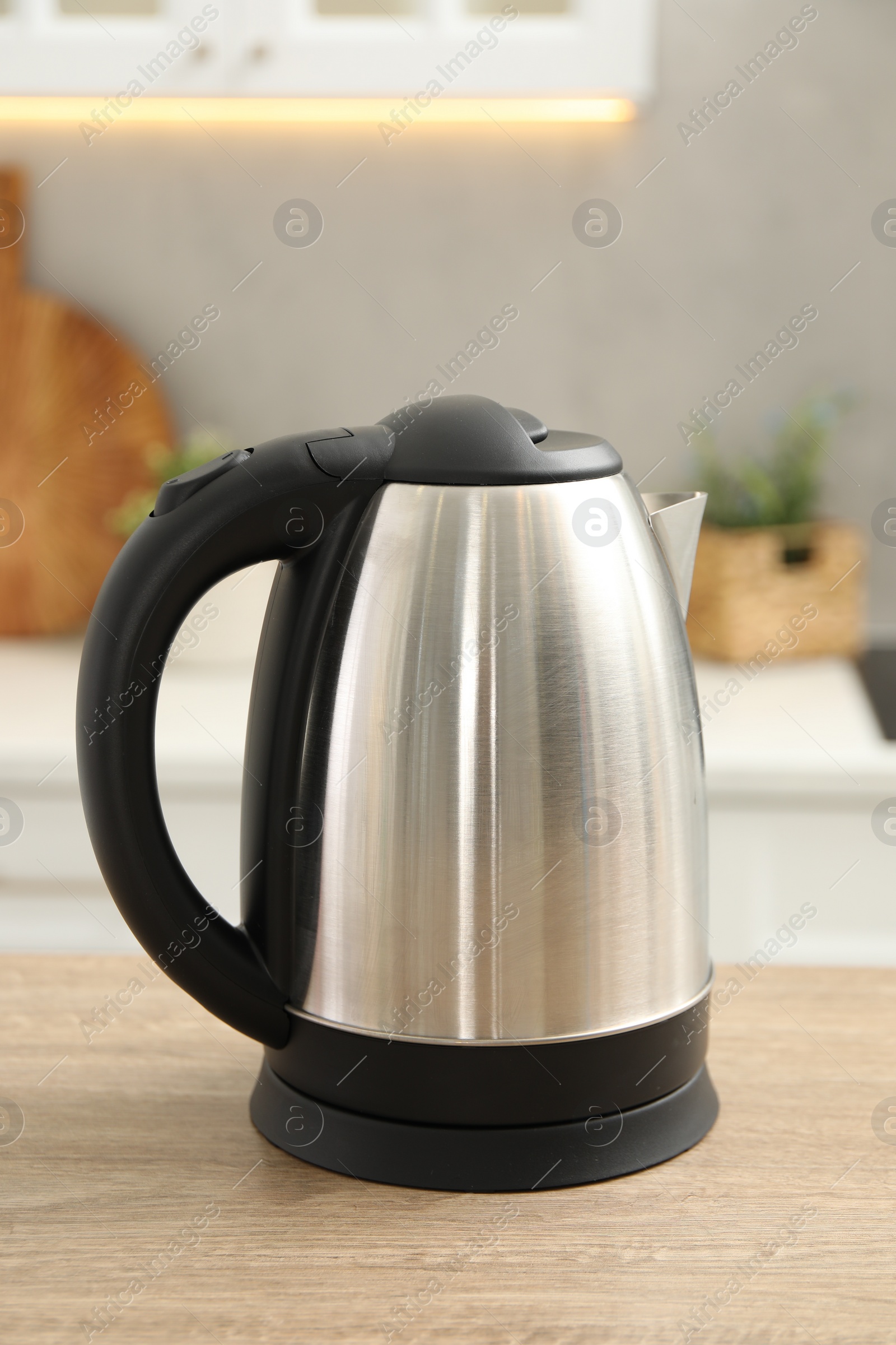 Photo of Modern electric kettle on table in kitchen