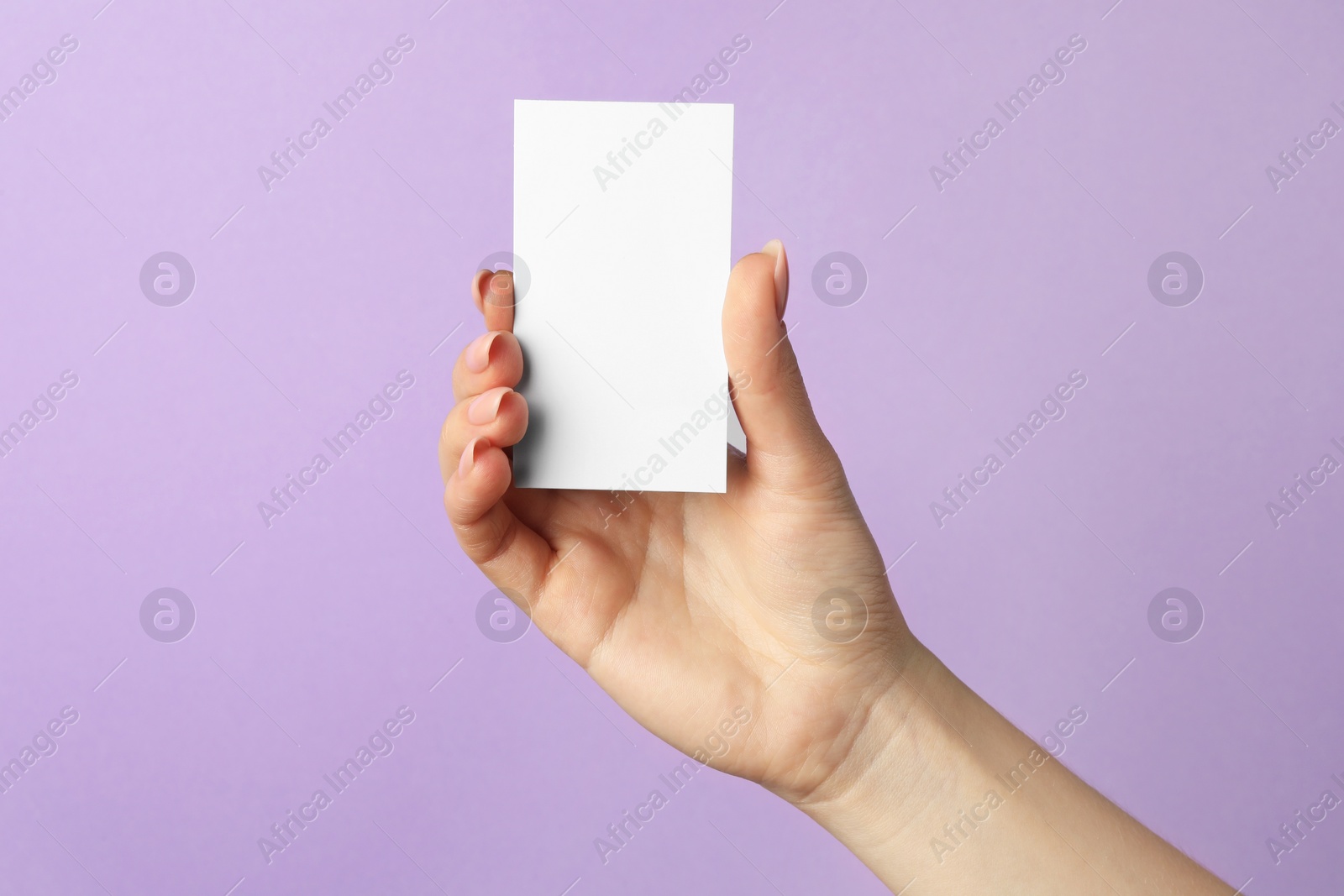 Photo of Woman holding blank business card on violet background, closeup. Mockup for design