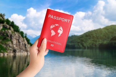 Image of Woman holding international passport and beautiful view of lake on background