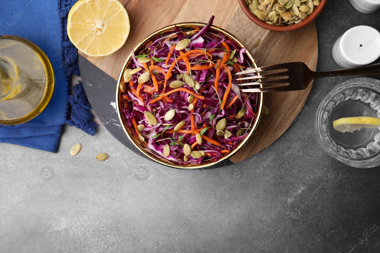 Photo of Eating tasty salad with red cabbage and pumpkin seeds on table, flat lay. Space for text