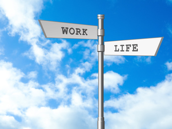 Image of Signpost against beautiful blue sky. Concept of balance between work and life