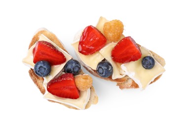 Photo of Tasty sandwiches with brie cheese and fresh berries isolated on white, top view