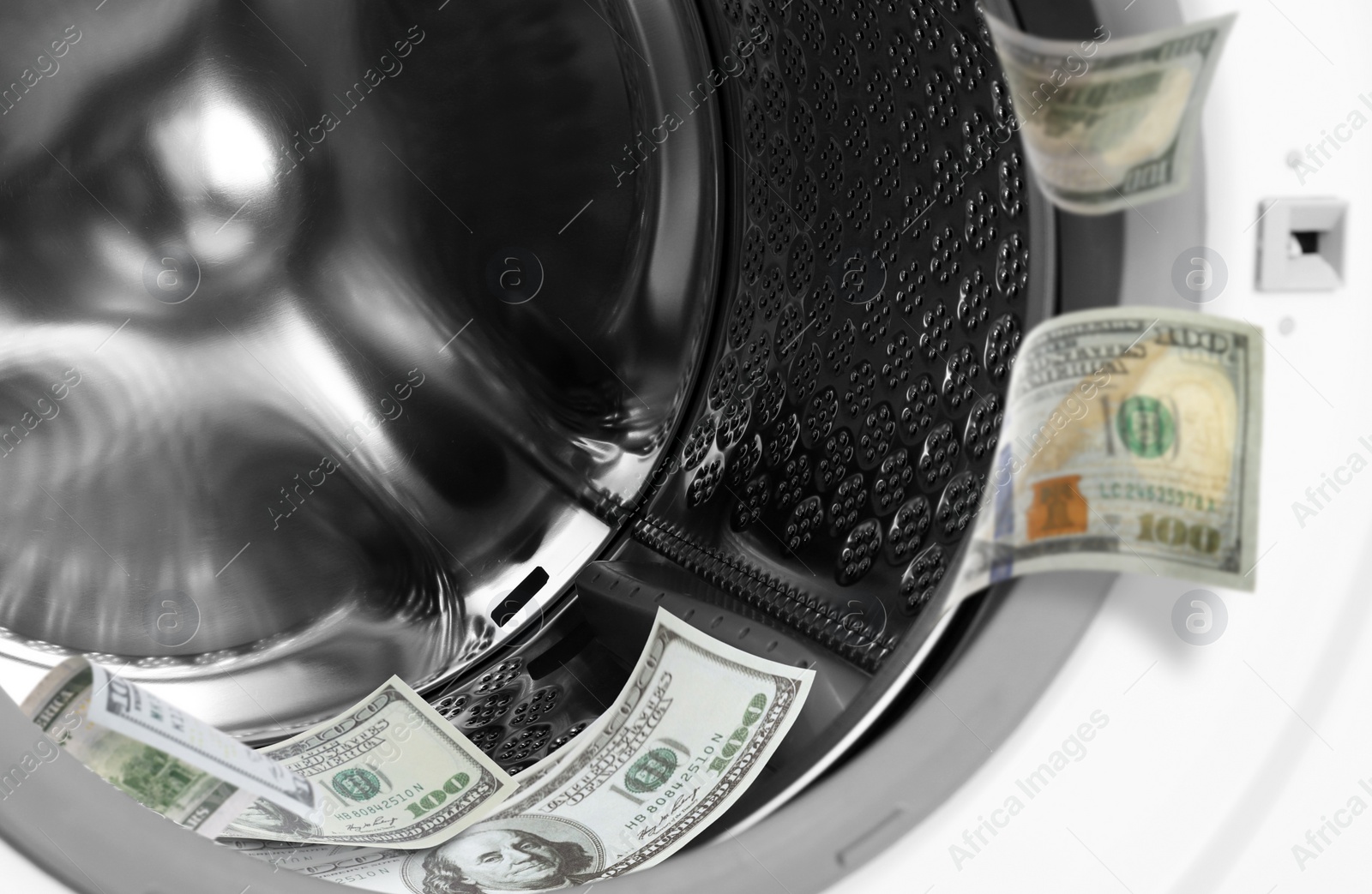 Image of Money laundering. Many dollar banknotes in washing machine