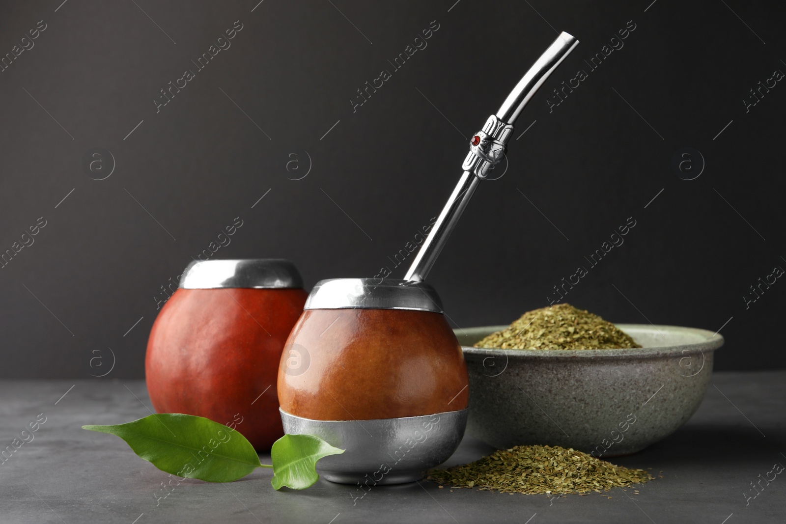 Photo of Calabashes with mate tea and bombilla on light grey table