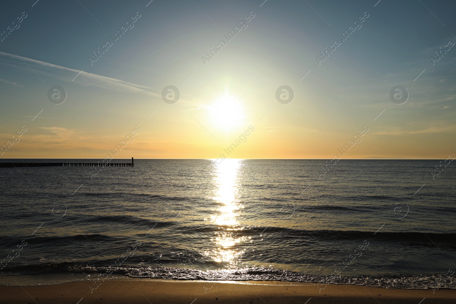 Photo of Picturesque view of sandy beach and sea at sunset