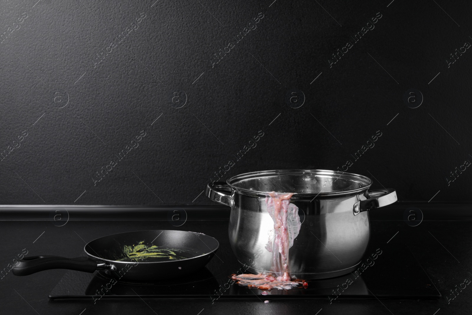 Photo of Dirty pot and frying pan on cooktop in kitchen