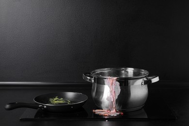 Dirty pot and frying pan on cooktop in kitchen