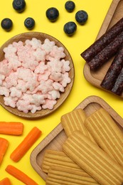 Photo of Different finger foods for baby on yellow background, flat lay