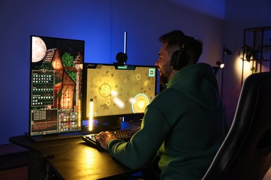 Photo of Man playing video games on computer at table indoors