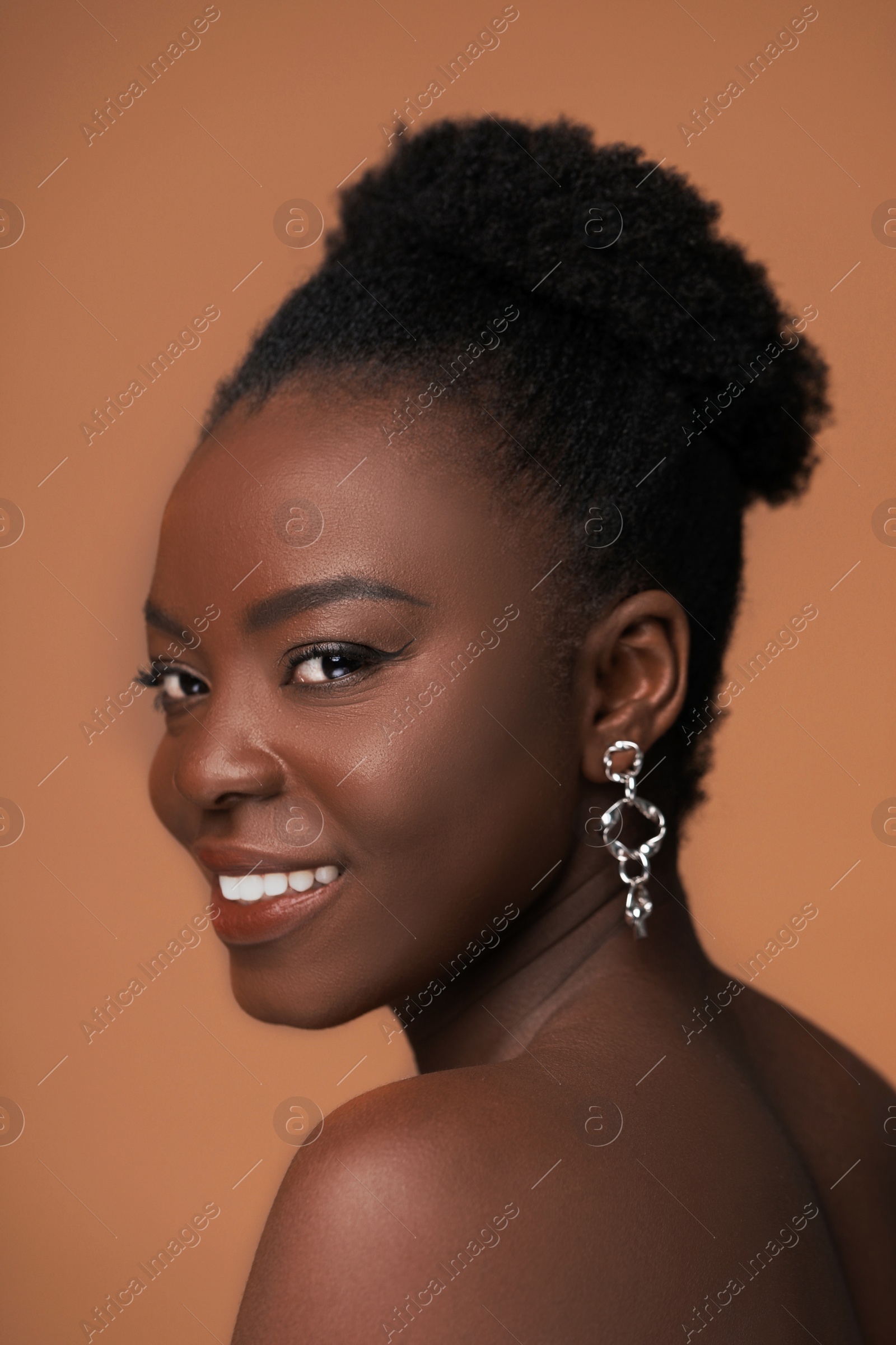 Photo of Fashionable portrait of beautiful happy woman on light brown background