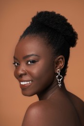 Photo of Fashionable portrait of beautiful happy woman on light brown background