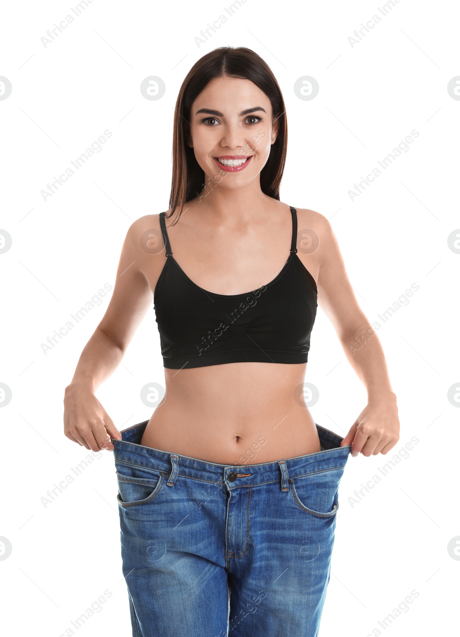 Photo of Attractive young woman with slim body wearing her old big jeans on white background