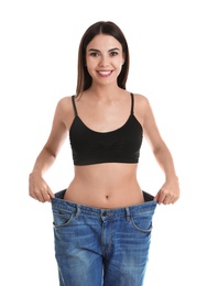 Photo of Attractive young woman with slim body wearing her old big jeans on white background